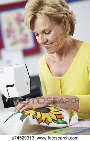 Stock Image - Two Women Using Electric Sewing Machine. Fotosearch