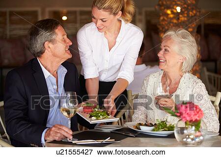 Waitress Serving Food To Senior Couple In Restaurant View Large Photo Image Stock Photo - Waitress Serving Food To Senior Couple In Restaurant. Fotosearch