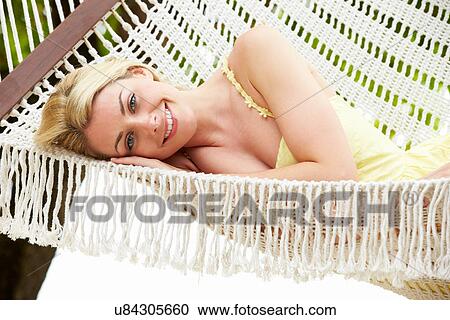 Stock Image - Woman Relaxing In Beach Hammock. Fotosearch