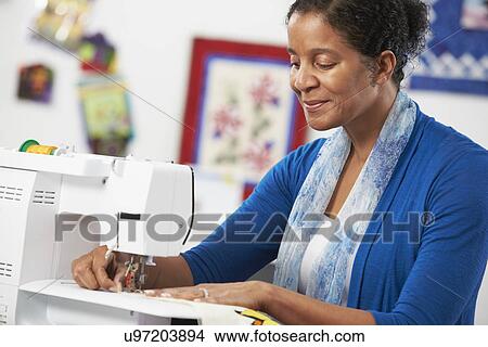 Picture - Woman Using Electric Sewing Machine. Fotosearch