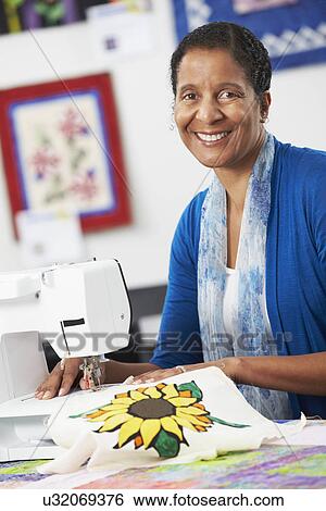 Stock Photograph - Woman Using Electric Sewing Machine. Fotosearch