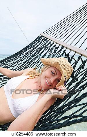 Woman Wearing Bikini And Sun Hat Relaxing In Beach Hammock View Large Photo Image Stock Photograph - Woman Wearing Bikini And Sun Hat Relaxing In Beach Hammock . Fotosearch