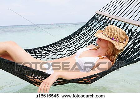 Woman Wearing Bikini And Sun Hat Relaxing In Beach Hammock View Large Photo Image Stock Photography - Woman Wearing Bikini And Sun Hat Relaxing In Beach Hammock . Fotosearch