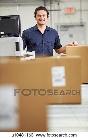 Stock Image - Worker Checking Goods On Belt In Distribution Warehouse. Fotosearch
