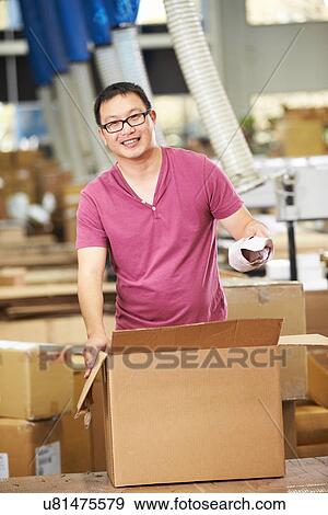 Stock Photo - Worker In Warehouse Preparing Goods For Dispatch. Fotosearch