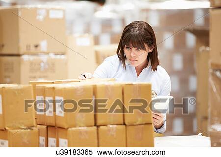 Stock Photography - Worker In Warehouse Preparing Goods For Dispatch. Fotosearch