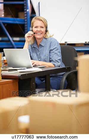 Worker In Warehouse Wearing Headset And Using Laptop View Large Photo Image Stock Image - Worker In Warehouse Wearing Headset And Using Laptop. Fotosearch