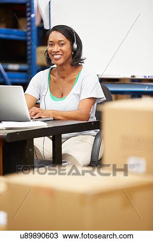 Worker In Warehouse Wearing Headset And Using Laptop View Large Photo Image Stock Image - Worker In Warehouse Wearing Headset And Using Laptop. Fotosearch