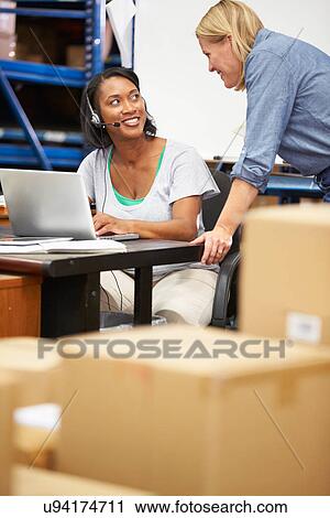 Worker In Warehouse Wearing Headset And Using Laptop View Large Photo Image Stock Image - Worker In Warehouse Wearing Headset And Using Laptop. Fotosearch