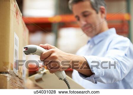 Stock Photo - Worker Scanning Package In Warehouse. Fotosearch