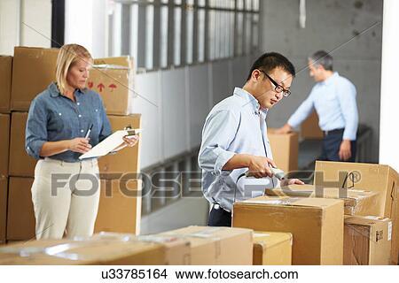 Picture - Workers Checking Goods On Belt In Distribution Warehouse. Fotosearch