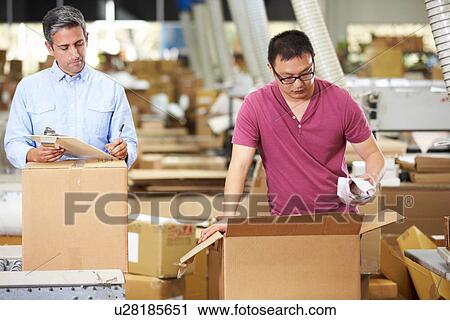 Stock Image - Workers In Warehouse Preparing Goods For Dispatch. Fotosearch