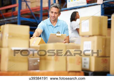 Stock Image - Workers In Warehouse Preparing Goods For Dispatch. Fotosearch