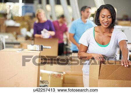 Stock Image - Workers In Warehouse Preparing Goods For Dispatch. Fotosearch