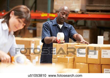 Stock Image - Workers In Warehouse Preparing Goods For Dispatch. Fotosearch