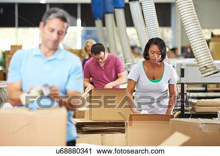 Stock Image - Workers In Warehouse Preparing Goods For Dispatch. Fotosearch