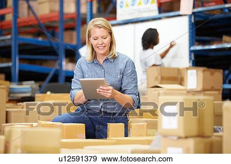 Stock Photo - Workers In Warehouse Preparing Goods For Dispatch. Fotosearch