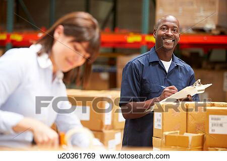 Stock Photo - Workers In Warehouse Preparing Goods For Dispatch. Fotosearch