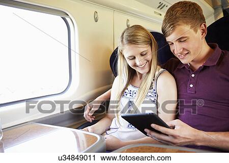 Young Couple Reading E Book On Train Journey View Large Photo Image Stock Image - Young Couple Reading E Book On Train Journey. Fotosearch