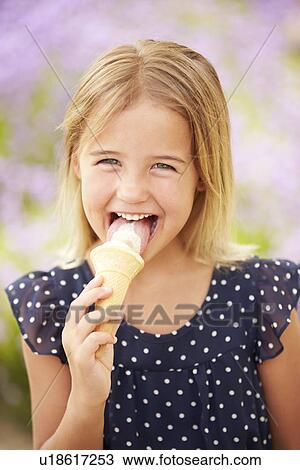 Stock Image - Young Girl Eating Ice Cream Outdoors. Fotosearch