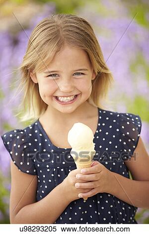 Stock Photography - Young Girl Eating Ice Cream Outdoors. Fotosearch