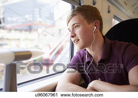 Young Man Listening To Music On Train Journey View Large Photo Image Stock Image - Young Man Listening To Music On Train Journey. Fotosearch