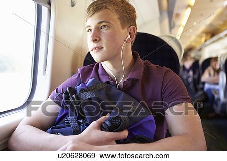 Young Man Listening To Music On Train Journey View Large Photo Image Stock Photo - Young Man Listening To Music On Train Journey. Fotosearch