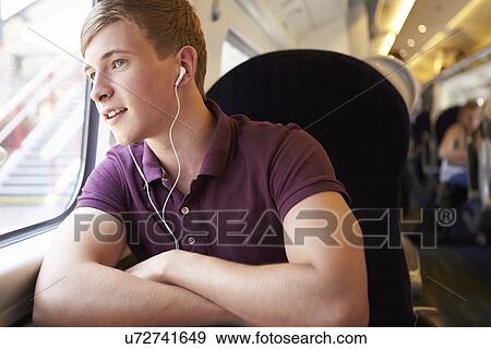 Young Man Listening To Music On Train Journey View Large Photo Image Stock Photo - Young Man Listening To Music On Train Journey. Fotosearch