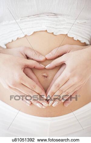 Couple holding pregnant woman's abdomen View Large Photo Image Stock Image - Couple holding pregnant woman's abdomen. Fotosearch