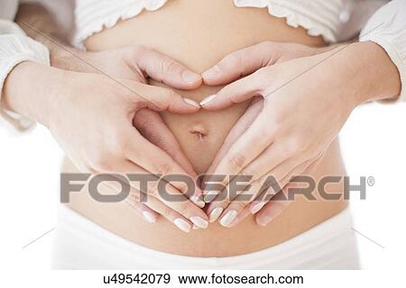 Stock Photo - Couple holding pregnant woman's abdomen. Fotosearch