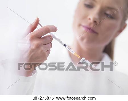 Stock Photography - Doctor preparing injection. Fotosearch