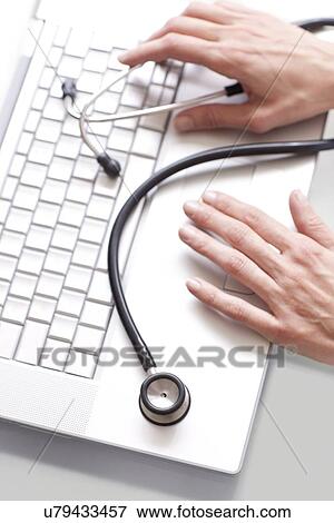Doctor using a laptop View Large Photo Image Stock Photo - Doctor using a laptop. Fotosearch