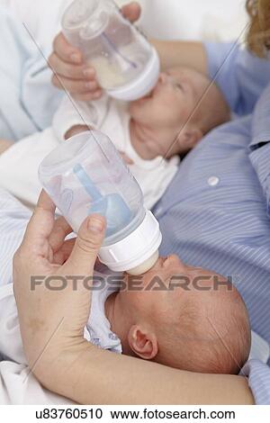 Mother feeding two week old twins View Large Photo Image Stock Image - Mother feeding two week old twins. Fotosearch