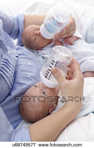 Mother feeding two week old twins View Large Photo Image Stock Photo - Mother feeding two week old twins. Fotosearch
