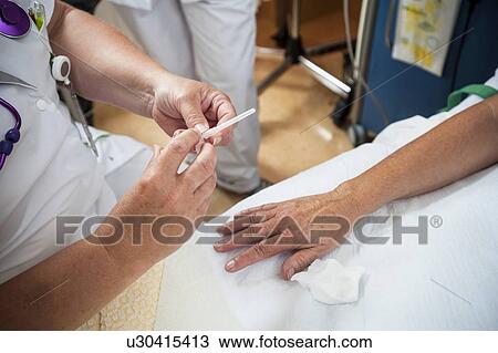 Stock Image - Nurse preparing a patient for an IV line. Fotosearch