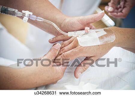 Nurse preparing a patient for an IV line View Large Photo Image Stock Image - Nurse preparing a patient for an IV line. Fotosearch