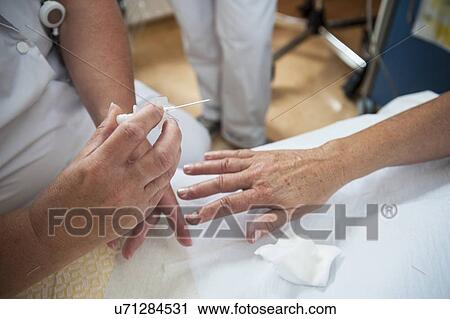 Nurse preparing a patient for an IV line View Large Photo Image Stock Image - Nurse preparing a patient for an IV line. Fotosearch