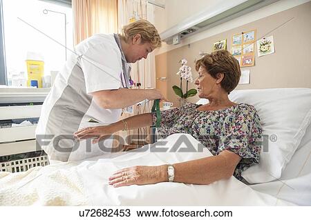 Stock Image - Nurse preparing a patient for an IV line. Fotosearch