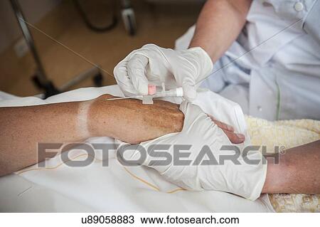 Stock Image - Nurse preparing a patient for an IV line. Fotosearch