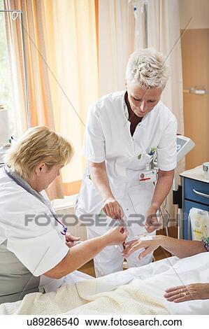 Nurse preparing a patient for an IV line View Large Photo Image Stock Image - Nurse preparing a patient for an IV line. Fotosearch