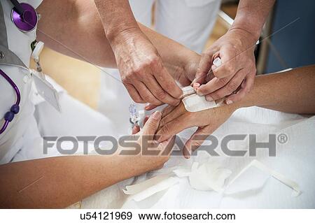 Nurse preparing a patient for an IV line View Large Photo Image Stock Photo - Nurse preparing a patient for an IV line. Fotosearch