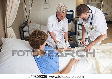 Stock Photograph - Nurse preparing a patient for an IV line. Fotosearch