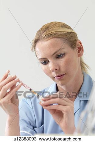 Stock Image - Nurse preparing injection. Fotosearch