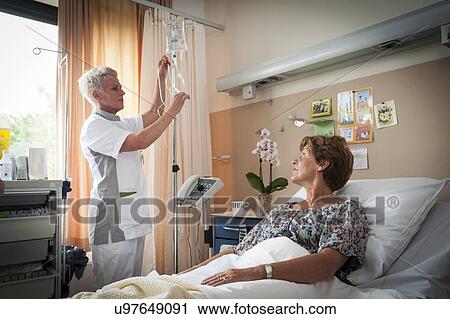 Stock Image - Nurse preparing IV drip. Fotosearch