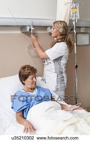 Stock Image - Nurse preparing nasal cannula for patient. Fotosearch