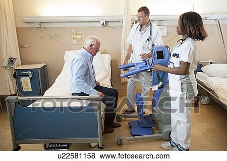 Nurses helping a patient out of bed View Large Photo Image Stock Photo - Nurses helping a patient out of bed. Fotosearch
