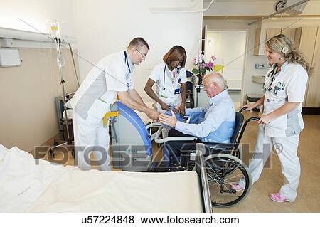 Nurses helping a patient out of bed View Large Photo Image Stock Photo - Nurses helping a patient out of bed. Fotosearch