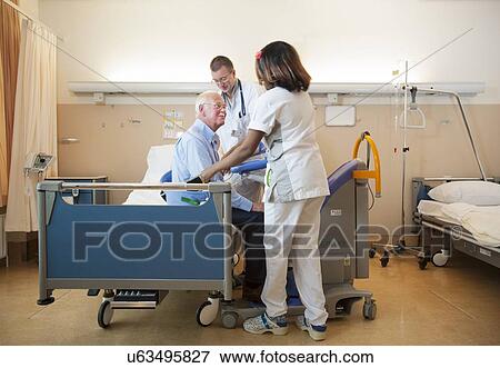 Nurses helping a patient out of bed View Large Photo Image Stock Photo - Nurses helping a patient out of bed. Fotosearch