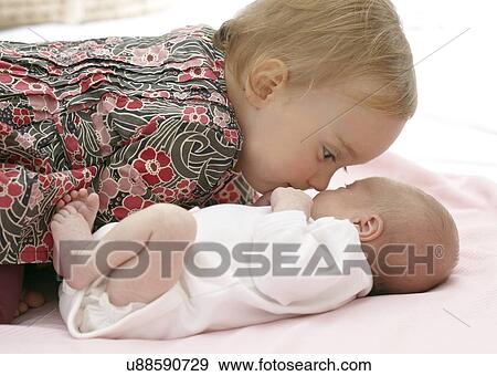 Stock Photo - One year old girl with baby sister. Fotosearch