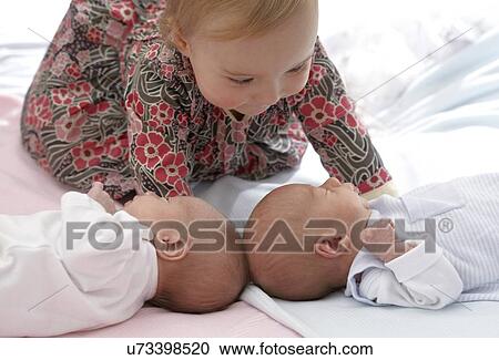 One year old girl with baby twin siblings View Large Photo Image Stock Image - One year old girl with baby twin siblings. Fotosearch